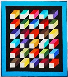 a colorful quilt is displayed on a blue tablecloth with black backing and white border