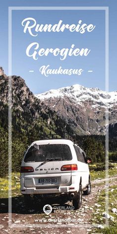 a white car parked on top of a dirt road in front of snow covered mountains