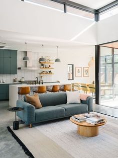 a living room filled with furniture next to a kitchen and an open floor plan on the wall