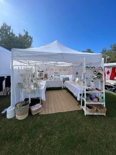 a white tent with tables and chairs under it