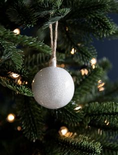 a white ornament hanging from a christmas tree