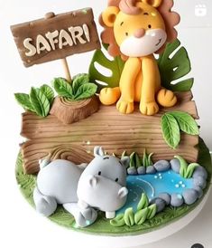 a cake with a lion and hippopotamus sitting on it's side