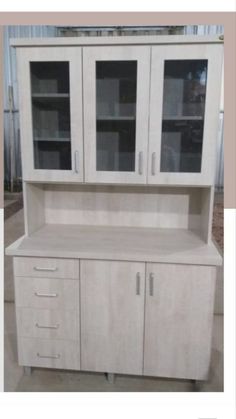 a white cabinet with glass doors and drawers