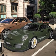 two cars parked next to each other in front of a tall building on the street