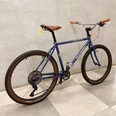 a blue bicycle is parked against a wall