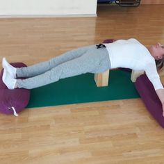 a woman laying on top of a yoga mat