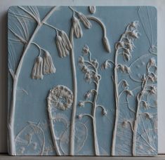 a blue tile with flowers and leaves on it