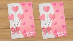 two valentine's day cards with pink paper hearts and bows on them, sitting on a wooden surface