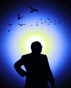 a person standing in front of a blue and yellow light with birds flying over them