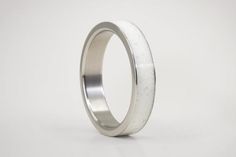 an image of a wedding ring made out of silver and white gold with a high polished finish