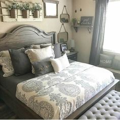 a large bed sitting next to a window with potted plants on top of it