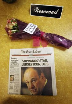 the paper is laying on top of the table next to some flowers and an umbrella