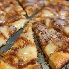 a close up of a sliced pizza on a pan with other slices cut into squares