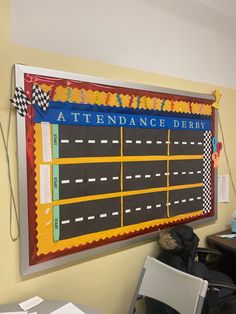 a large race track hanging on the wall next to a desk with chairs in front of it