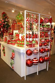 christmas decorations are displayed on display in a room with red and green balls, candy canes, and ornaments