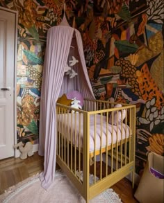 a baby crib in front of a colorful wallpaper