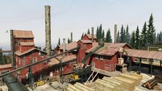 an aerial view of a building being built in the woods with lumber piled around it