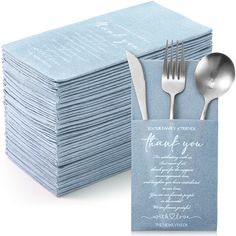 a stack of blue napkins with silverware next to it and a folded thank you card