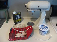 a white mixer sitting on top of a counter next to a cup of ice cream