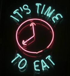 a neon sign that says it's time to eat with a clock in the middle