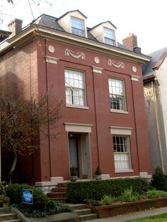 a red brick building with two story windows and steps leading up to the front door