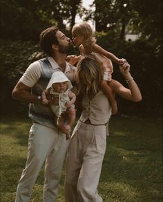 a man, woman and child are standing in the grass