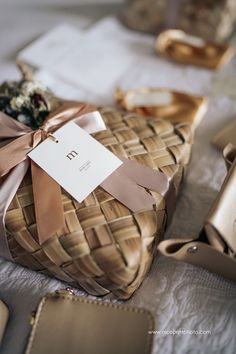 a basket with a tag tied to it sitting on top of a table next to other purses