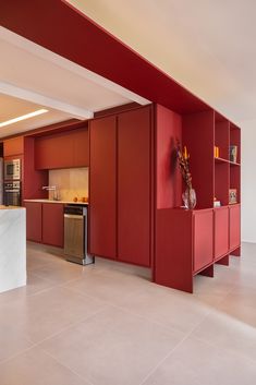 a kitchen with red cabinets and white counter tops