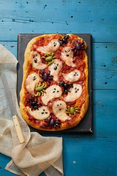 a pizza topped with lots of toppings sitting on top of a pan next to a knife