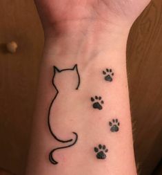 a woman's wrist with a cat and paw prints on the left side of her arm