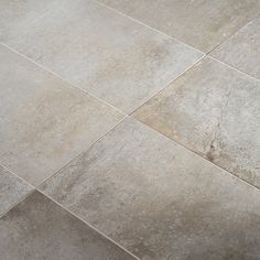 a white toilet sitting on top of a floor next to a tiled flooring area