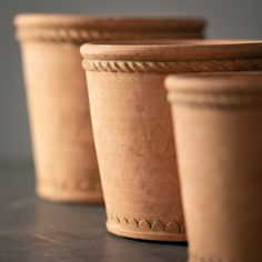 three clay pots sitting on top of a table