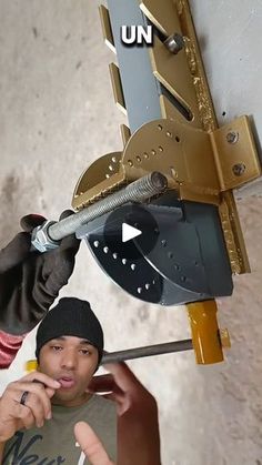 a young man is holding up a metal object