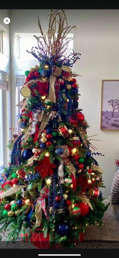 a decorated christmas tree with red, green and blue ornaments on it's base