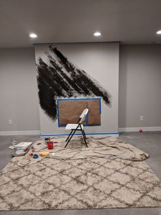 a painting is being worked on in a room with grey walls and white carpeting