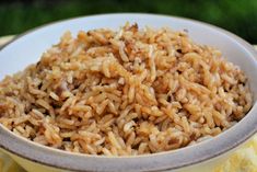 a white bowl filled with brown rice on top of a yellow cloth covered tablecloth