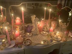 a table topped with lots of candles and dishes