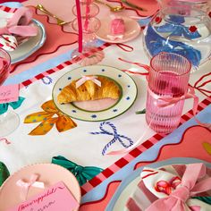 a table topped with lots of pink and white plates