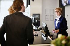 two women are talking to each other at the front desk