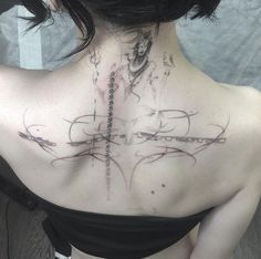 the back of a woman's neck with tattoos on her upper and lower part