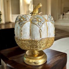 a decorative glass pumpkin sitting on top of a wooden table