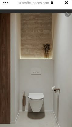 a white toilet sitting inside of a bathroom next to a wall mounted paper dispenser