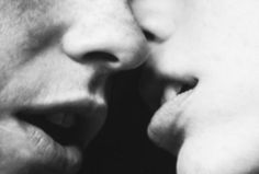 a man and woman kissing each other with their noses close to one another, black and white photograph