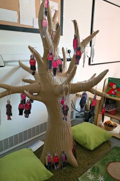 a tree made out of cardboard with people hanging from it