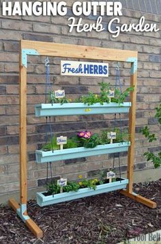 hanging gutter herb garden in front of a brick wall with text overlay reading hanging gutter herb garden