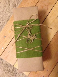 a wrapped gift with a deer on it sitting on top of a wooden floor next to a rug