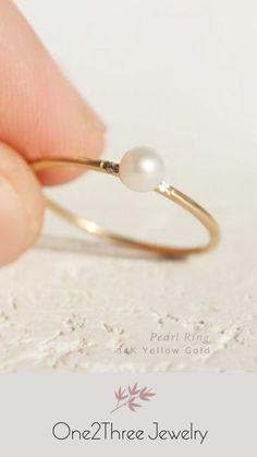 a person holding a pearl ring in their hand