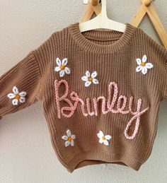 Hi there 👋 I'm Tori! I'm so glad you're here!! Follow along with me on my Instagram page for inspiration @brookesandhudsknitco These custom hand embroidered name sweaters are great for monthly growth pictures, baby showers, name announcements, birthday's, and so much more! Let's make something cute together!! :) Name On Sweater, Customized Baby Gifts, Growth Pictures, Name Sweater Baby, Sweater With Name, Baby Name Sweater, Hand Embroidered Name, Toddler Boy Sweater, Name Sweater