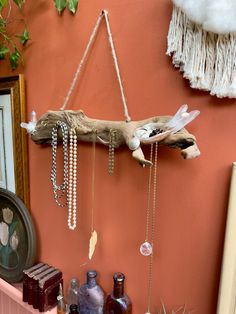 a wooden branch with beads hanging from it's sides on a wall next to other items