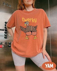 Comfort Colors® Twerky Turkey Shirt, Thanksgiving Turkey Shirt, Funny Thanksgiving Tee, Family Thanksgiving Dinner Gift, Dancing Turkey Tee Thank you so much for visiting my Etsy Shop! I love each product we sell and they're made with love and care, so I hope you love them as well!  I've chosen my favorite Comfort Colors® color options for you, I had all colors on my own and I'm never getting bored of them! :)    Introducing Our Premium Comfort Colors Tees; Comfort Colors® Tess are made from soft, garment-dyed fabric. The rich, vibrant, and pastel colors will be your go to choice in every casual or special occasion!  Each product is a premium, pre-washed finish that resist fading for a long time and ensuring you stay stylish wear after wear!  Crafted from 100% ring-spun cotton with a subst Funny Thanksgiving Shirts Couples, Funny Orange Crew Neck Top, Oversized Funny Crew Neck Top, Trendy Tan Tops With Screen Print, Funny Short Sleeve Tops For Fall, Oversized Orange Tops With Letter Print, Oversized Orange Top With Letter Print, Trendy Tan Tops For Fall, Turkey Trot Shirts Ideas